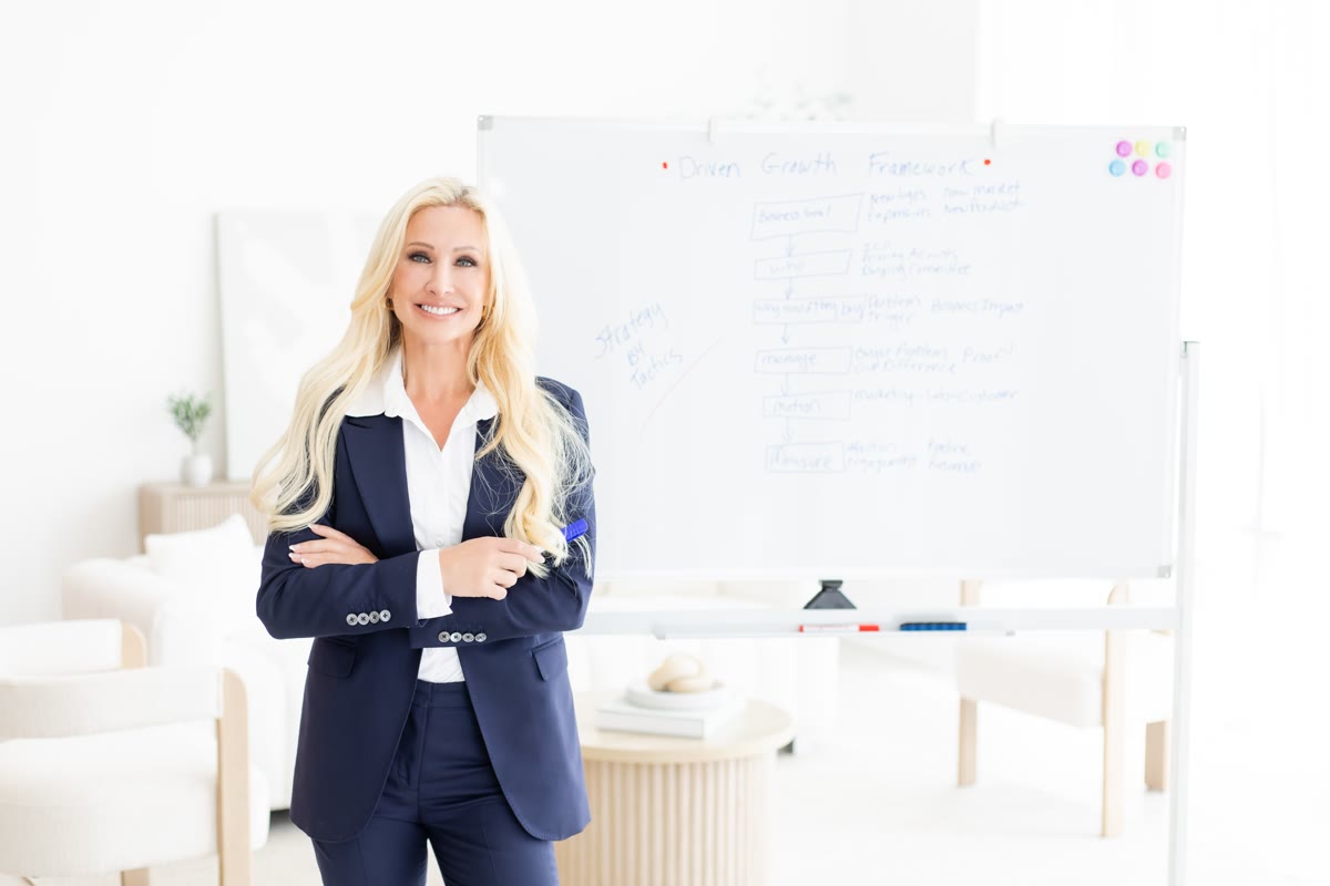 Caroline Lyle in front of the Driven Growth Framework on a whiteboard